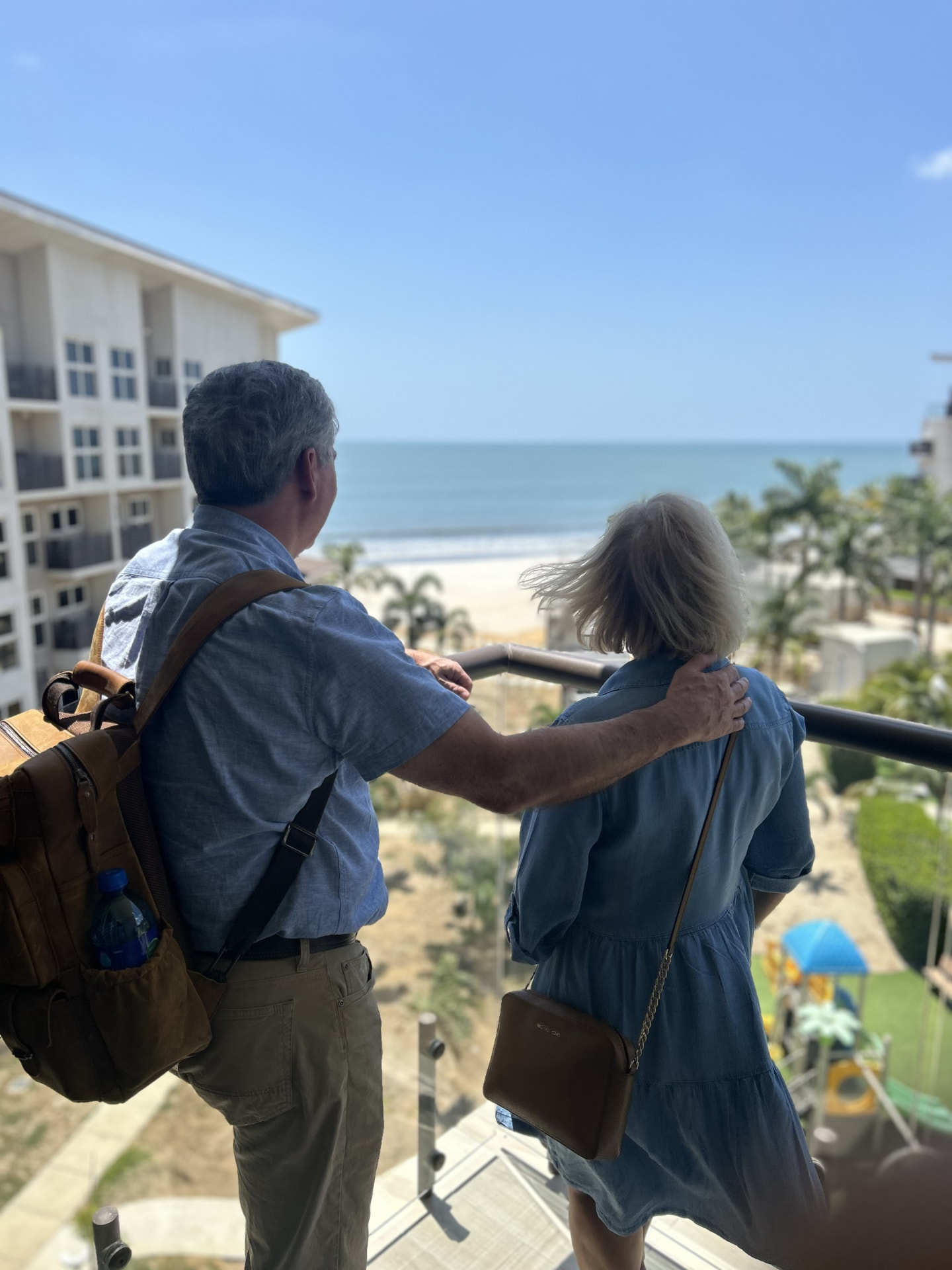 Retired couple on a balcony looking out over the beach and ocean in Panama