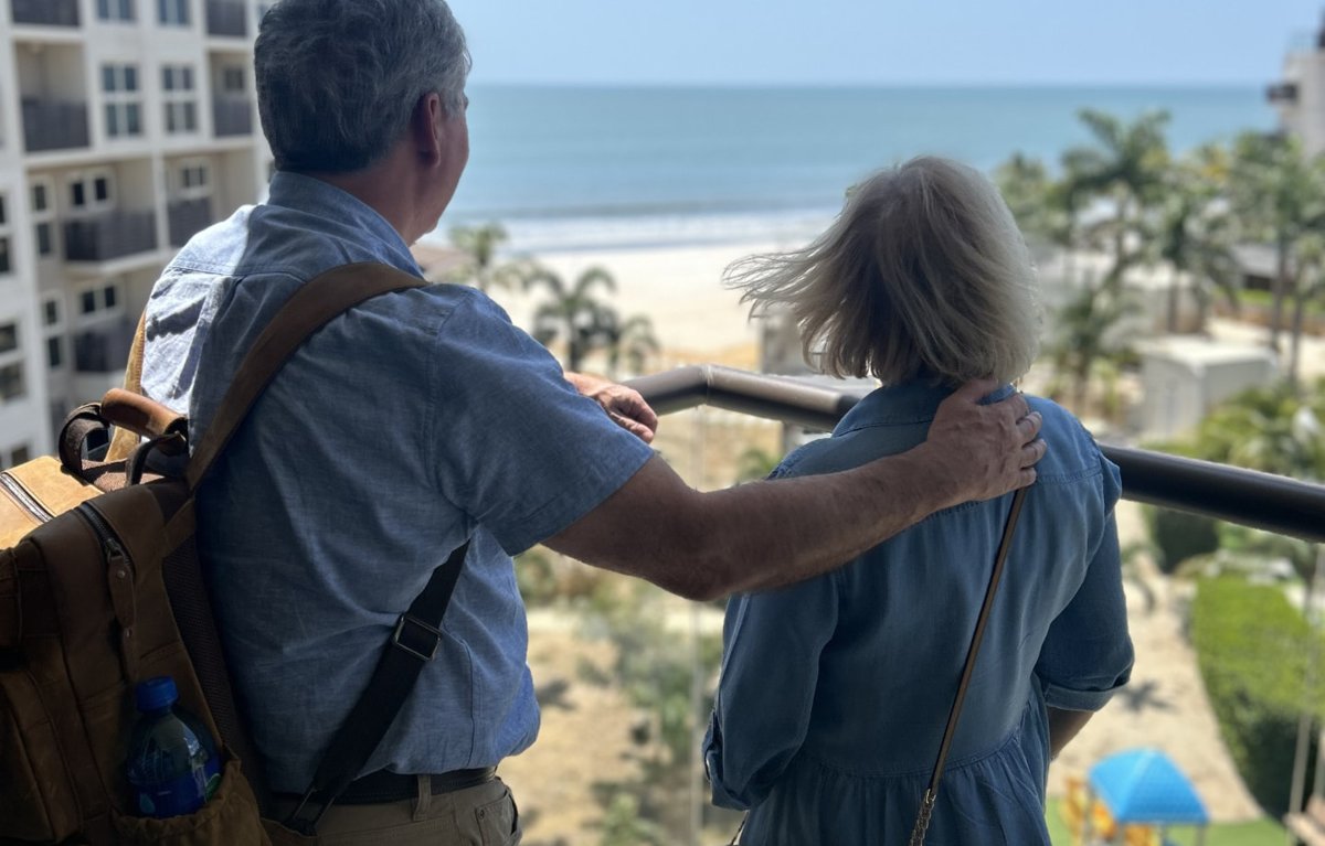 Retired couple looking out at the ocean from their Panama balcony
